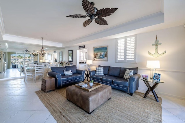 living room with a raised ceiling, plenty of natural light, and ceiling fan with notable chandelier