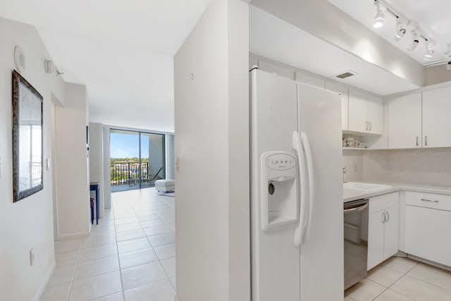 kitchen with light tile patterned floors, visible vents, white cabinetry, white refrigerator with ice dispenser, and stainless steel dishwasher