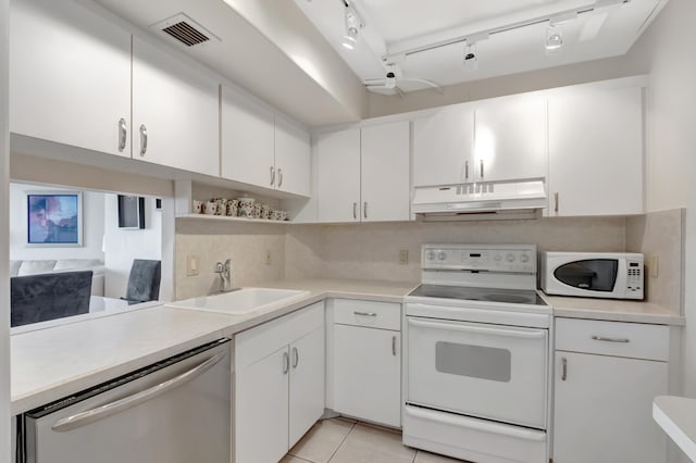 kitchen with white appliances, visible vents, a sink, light countertops, and under cabinet range hood