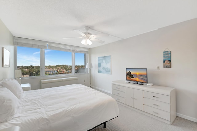 bedroom with light carpet, a ceiling fan, and baseboards