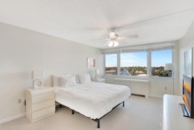 bedroom with a ceiling fan, baseboards, and light carpet