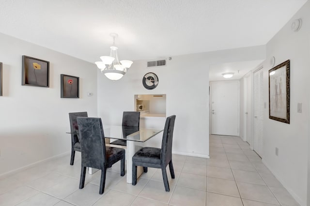 dining space with light tile patterned floors, visible vents, baseboards, and a chandelier