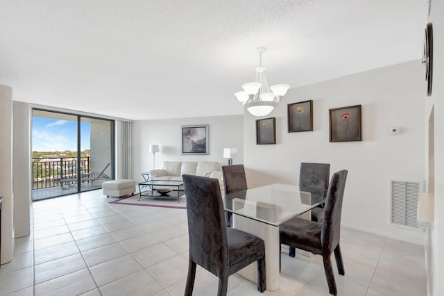 dining space with visible vents, a notable chandelier, expansive windows, light tile patterned floors, and baseboards