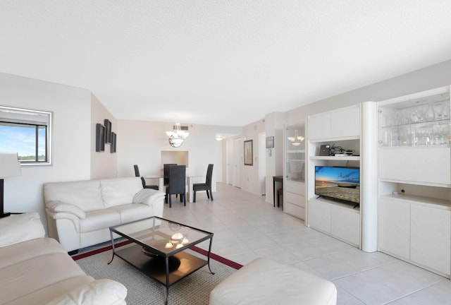 living area featuring light tile patterned floors, a textured ceiling, and an inviting chandelier