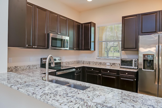 kitchen featuring a sink, light stone counters, stainless steel appliances, dark brown cabinetry, and a toaster