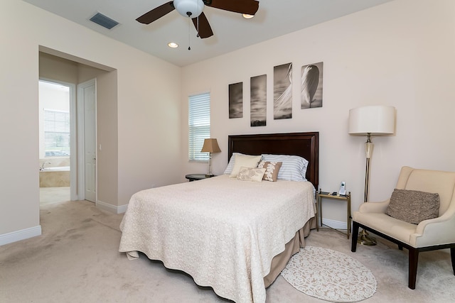 bedroom featuring baseboards, visible vents, ceiling fan, ensuite bathroom, and light carpet