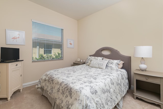 bedroom featuring light colored carpet and baseboards