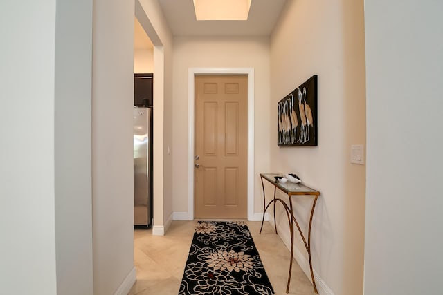 doorway to outside featuring light tile patterned floors and baseboards