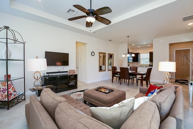 living area featuring visible vents, recessed lighting, baseboards, and a tray ceiling