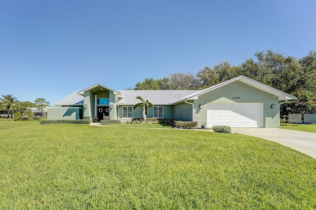 view of front of house with driveway, an attached garage, stucco siding, a front lawn, and metal roof