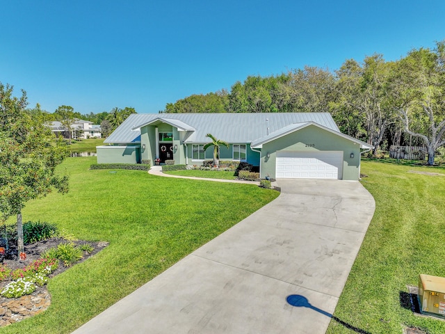 view of front of home with a front yard, a standing seam roof, an attached garage, concrete driveway, and metal roof