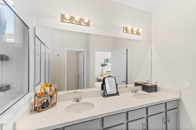 bathroom with double vanity, a stall shower, and a sink