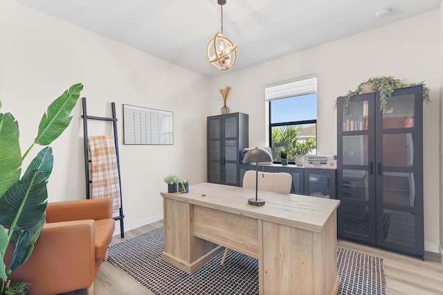 office area with light wood-style floors and baseboards