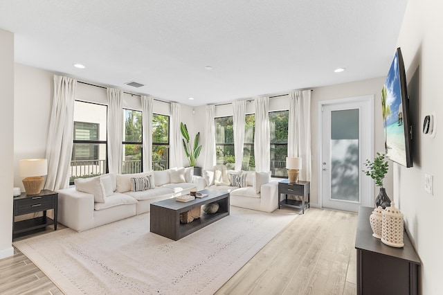 living area featuring recessed lighting, wood finished floors, and visible vents