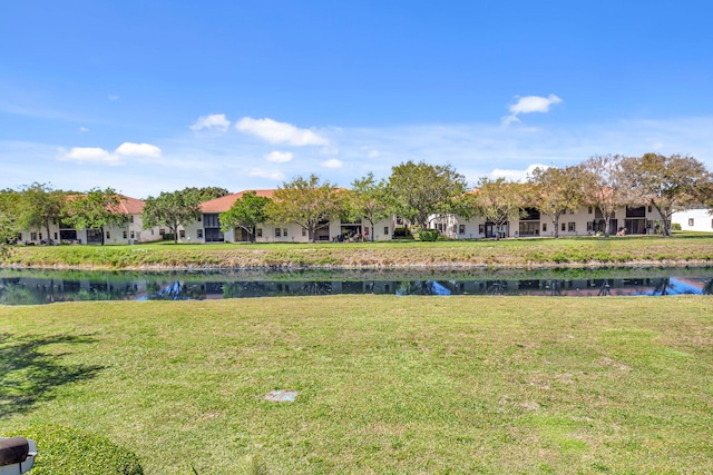 view of yard with a residential view and a water view