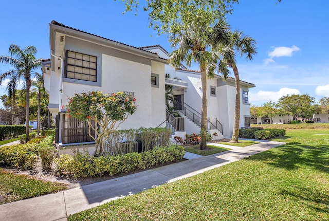 view of front facade featuring a front lawn and stucco siding