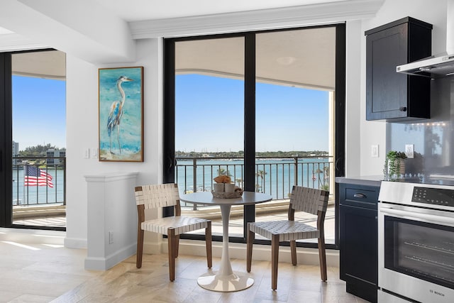 kitchen with a healthy amount of sunlight, dark cabinets, wall oven, and expansive windows