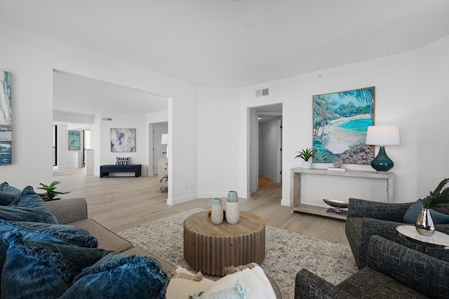 living room with visible vents, baseboards, and wood finished floors