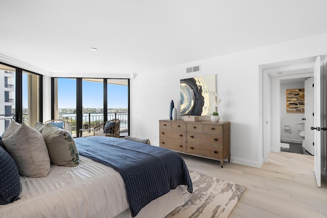 bedroom featuring a water view, access to outside, floor to ceiling windows, light wood finished floors, and baseboards