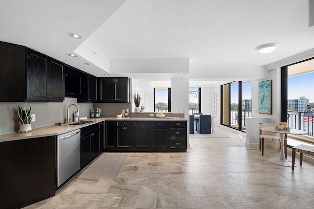 kitchen with dark cabinetry, recessed lighting, a sink, light countertops, and dishwasher