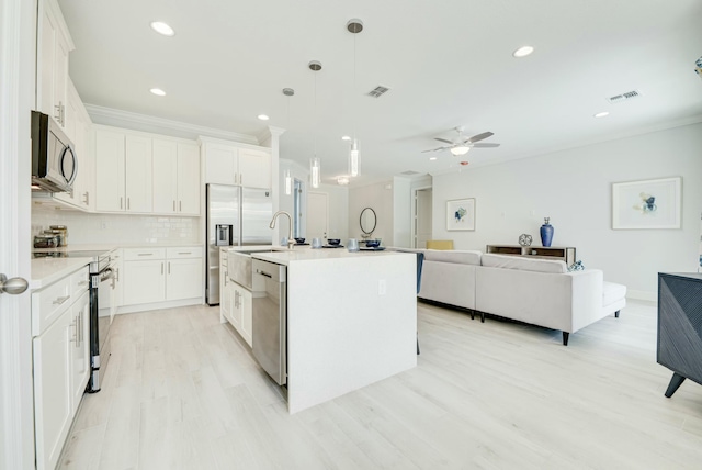 kitchen with visible vents, appliances with stainless steel finishes, crown molding, and decorative backsplash