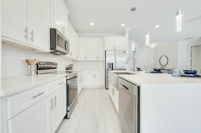 kitchen with light wood finished floors, white cabinets, appliances with stainless steel finishes, crown molding, and tasteful backsplash