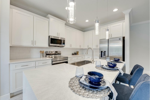 kitchen with an island with sink, ornamental molding, decorative backsplash, a sink, and appliances with stainless steel finishes