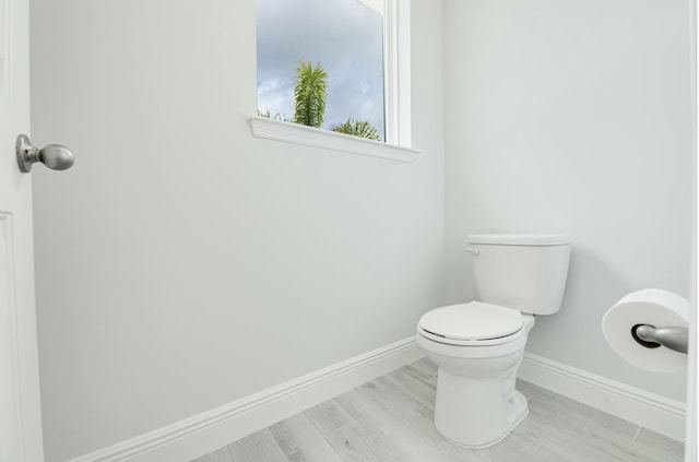 bathroom featuring baseboards, toilet, and wood finished floors