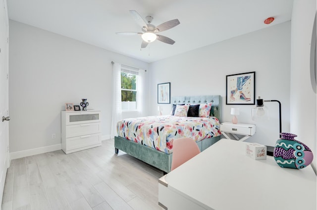 bedroom with ceiling fan, baseboards, and light wood-style floors