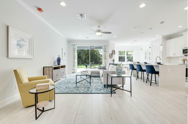 living area featuring recessed lighting, visible vents, light wood-style flooring, and crown molding