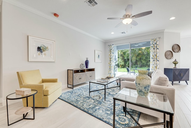 living room with visible vents, ornamental molding, ceiling fan, and wood finished floors