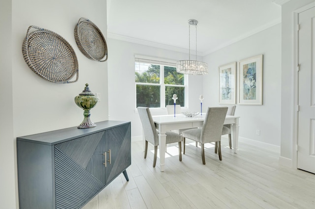 dining area with a chandelier, baseboards, light wood finished floors, and ornamental molding