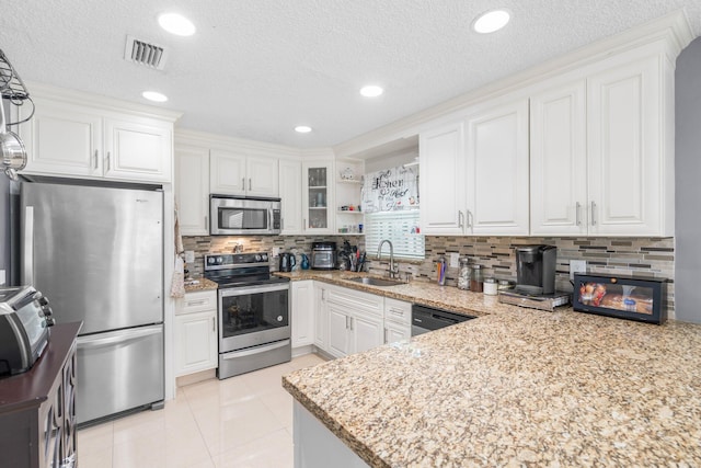 kitchen with visible vents, white cabinets, stainless steel appliances, and a sink