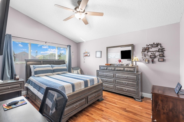 bedroom featuring light wood-type flooring, a textured ceiling, baseboards, lofted ceiling, and ceiling fan