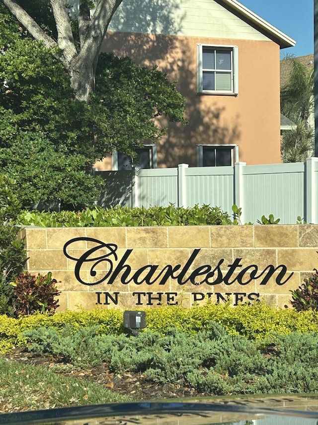 community / neighborhood sign featuring fence