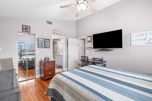 bedroom with visible vents, a textured ceiling, wood-type flooring, lofted ceiling, and ceiling fan