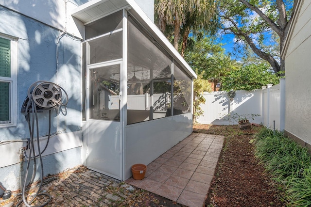 view of home's exterior with a fenced backyard and a sunroom