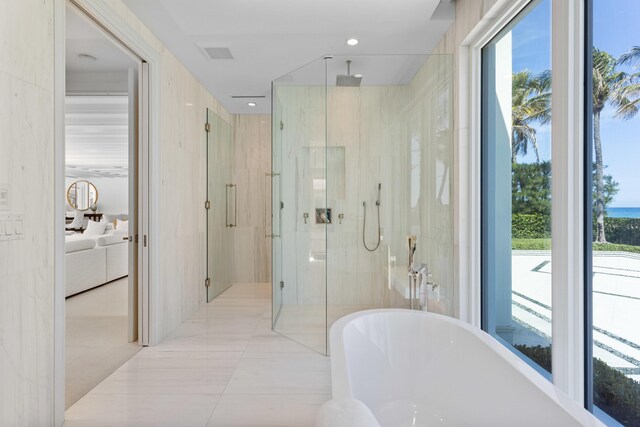 ensuite bathroom featuring visible vents, connected bathroom, a stall shower, and a freestanding bath