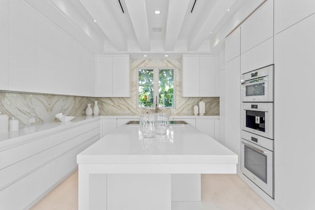 kitchen featuring backsplash, white double oven, light countertops, white cabinetry, and modern cabinets