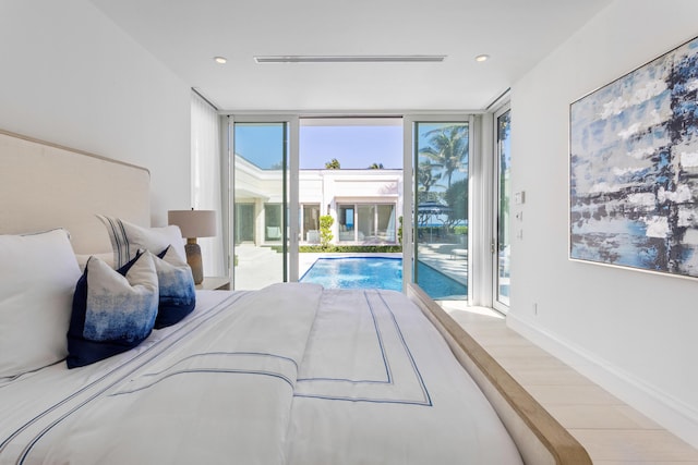 bedroom with access to outside, wood finished floors, floor to ceiling windows, recessed lighting, and baseboards