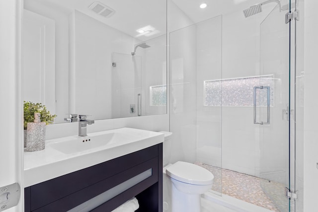 full bath with visible vents, toilet, a stall shower, and vanity