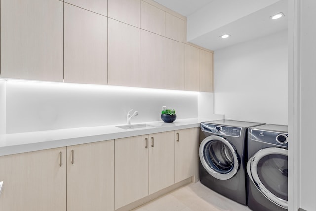 washroom featuring cabinet space, recessed lighting, separate washer and dryer, and a sink