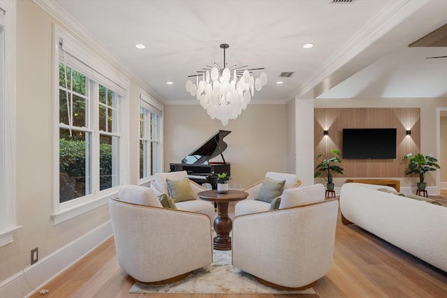 living area featuring baseboards, visible vents, crown molding, a notable chandelier, and light wood-type flooring