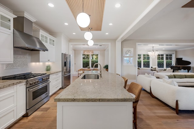 kitchen featuring a sink, appliances with stainless steel finishes, a kitchen breakfast bar, open floor plan, and a chandelier