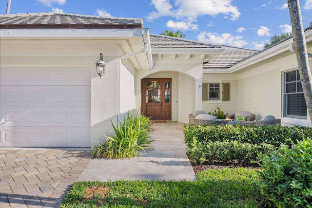 property entrance featuring stucco siding and an attached garage