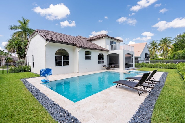 back of property with a tiled roof, a lawn, a fenced backyard, a balcony, and a patio