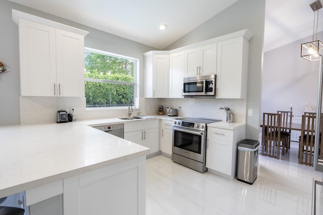 kitchen featuring lofted ceiling, a sink, decorative backsplash, appliances with stainless steel finishes, and white cabinetry