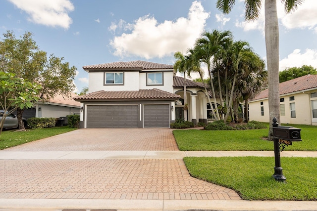 mediterranean / spanish-style home with stucco siding, a front lawn, decorative driveway, an attached garage, and a tiled roof