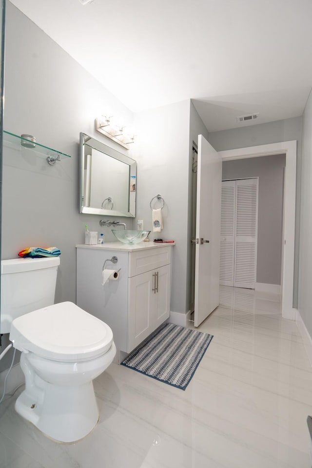 bathroom with visible vents, toilet, vanity, and baseboards