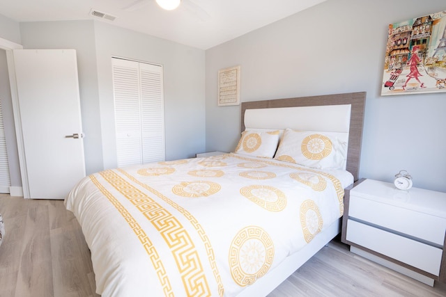 bedroom with ceiling fan, visible vents, a closet, and wood finished floors